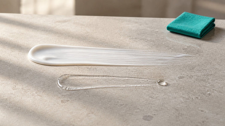 An opaque white gel swipe and a clear serum swipe side by side on pale stone, showing two acne actives used in one routine