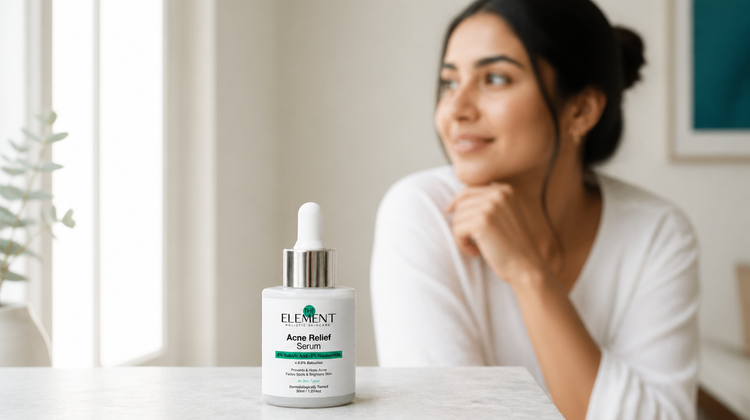The Element 2% Salicylic Acid + 5% Niacinamide Acne Relief Serum on a marble table, with a woman relaxing in soft window light behind