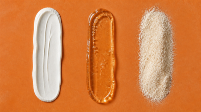 Three swatches side by side on a terracotta tile - an opaque white cream, a clear amber gel and a fine ivory powder - comparing three brightening actives