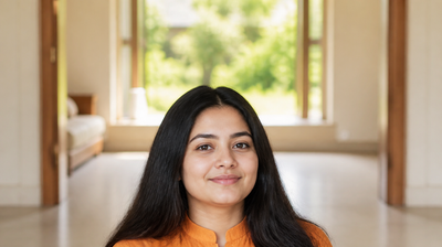 Young Indian woman in an orange kurta with fresh, evenly hydrated skin after her morning CTMP skincare routine, sunlit window behind her