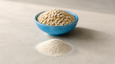 A blue bowl of rolled oats beside a mound of finely ground colloidal oat flour