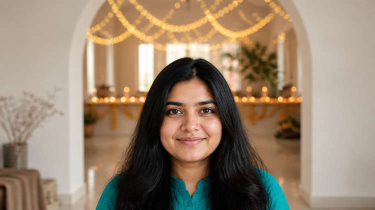 A young Indian woman with clear, calm skin at home, with Diwali lights, diyas and marigolds glowing behind her