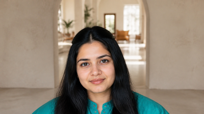 Indian woman in her late twenties in a teal kurta with natural skin texture and visible pores in a sunlit archway