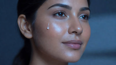 Indian woman's face looking hydrated and plump but matte, water droplet on cheek, hyaluronic acid for oily skin