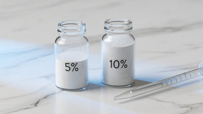Two glass vials of niacinamide at 5 percent and 10 percent concentration on white marble
