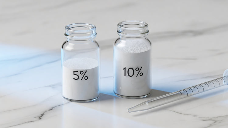 Two glass vials of niacinamide at 5 percent and 10 percent concentration on white marble