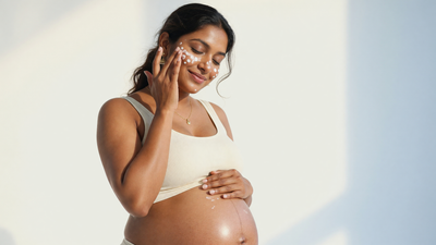 Pregnant Indian woman applying gentle pregnancy-safe skincare to her face