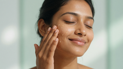 Indian woman with clear smooth glowing skin applying serum to her cheek